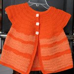 Little Girl's Sweater Dress — a knitted orange short-sleeved baby dress with white buttons