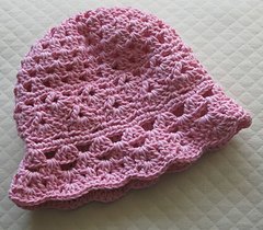 Scalloped Baby Hat — a pink crocheted baby hat with a delicate scalloped lace brim